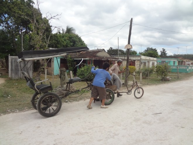 An ancient bici-taxi gets a tow from a cargo bike